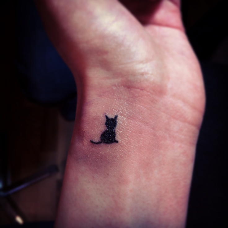 tiny cat tattoo design on wrist